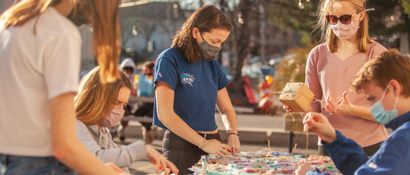 学生 prepare to put string lights up around downtown Biddeford, Maine